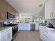 Bright, open kitchen featuring modern appliances, two-toned cabinetry, and long countertops that looks out to the living space at 9369 Villa Ridge Dr, Las Vegas, NV 89134