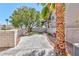 Private fenced backyard featuring a concrete patio area, low maintenance gravel bed, and mature trees at 9979 Keephills St, Las Vegas, NV 89183