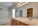 Bright bathroom featuring a double sink vanity, large mirror, and bathtub with shower at 9994 Government Point Way # 101, Las Vegas, NV 89183