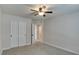 Spacious bedroom with neutral carpet, ceiling fan and double door closet at 9994 Government Point Way # 101, Las Vegas, NV 89183