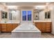 Luxurious bathroom featuring a soaking tub and dual vanities with wood cabinets and sleek lighting at , Las Vegas, NV 89117