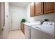 Spacious laundry room with side-by-side washer and dryer and storage cabinets at , Las Vegas, NV 89117