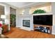 Open-concept living room featuring a cozy fireplace, large TV, and warm wood flooring at , Las Vegas, NV 89117