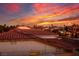 Panoramic sunset view over rooftops with red tile roofs and palm trees in the distance at , Las Vegas, NV 89117