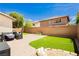 A cozy backyard featuring a paved patio, artificial grass, and a charming seating area at , Las Vegas, NV 89178