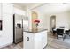 Open concept kitchen with white cabinetry, stainless steel refrigerator, island, and adjacent dining area at , Las Vegas, NV 89178