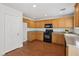 Bright kitchen featuring wood cabinets, gray counters, and black appliances at 1043 Monte De Oro Ave, Las Vegas, NV 89183