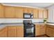 Kitchen featuring wooden cabinets, black appliances, and speckled countertops at 1043 Monte De Oro Ave, Las Vegas, NV 89183