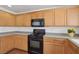 Kitchen with wooden cabinets, black appliances, and speckled countertops at 1043 Monte De Oro Ave, Las Vegas, NV 89183