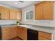 Kitchen area with wooden cabinets, speckled countertop, and a bright window above the double sink at 1043 Monte De Oro Ave, Las Vegas, NV 89183