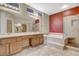 Well-lit bathroom featuring a double vanity, soaking tub, glass-enclosed shower, and modern fixtures at 10608 Trussell St, Las Vegas, NV 89141