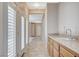 Hallway featuring a sink, tile floors, wood cabinets, and shutter doors with view of the backyard at 10608 Trussell St, Las Vegas, NV 89141