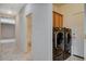 Hallway with laundry area and a doorway to bathroom featuring tile flooring at 10608 Trussell St, Las Vegas, NV 89141