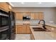 Modern kitchen features stainless steel appliances, wooden cabinetry, and stone countertops at 10608 Trussell St, Las Vegas, NV 89141
