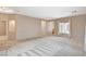 Open living room with tile and carpet flooring, neutral tones, and abundant natural light at 10608 Trussell St, Las Vegas, NV 89141
