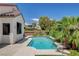 Beautiful backyard pool with a clean, blue interior, surrounded by palm trees and lush landscaping at 10608 Trussell St, Las Vegas, NV 89141