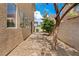 The property features low-maintenance desert landscaping with gravel and stone, complemented by a stone patio and mature trees at 10638 Pueblo Springs St, Las Vegas, NV 89183