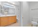 Bright bathroom with wood vanity, a large mirror, a shower-tub combo, and a toilet at 10638 Pueblo Springs St, Las Vegas, NV 89183