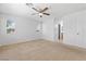 Bedroom featuring neutral walls and carpet, ceiling fan, and ample natural light from two windows at 10638 Pueblo Springs St, Las Vegas, NV 89183