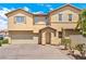 Two-story home featuring a stucco exterior, arched entryway, and a two-car garage, enhancing its curb appeal at 10638 Pueblo Springs St, Las Vegas, NV 89183