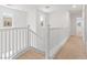 Bright hallway with white railing, carpeted floors and staircase, and natural light at 10638 Pueblo Springs St, Las Vegas, NV 89183
