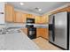Modern kitchen boasts stainless steel appliances, wood cabinets, and granite countertops, blending style with functionality at 10638 Pueblo Springs St, Las Vegas, NV 89183