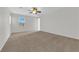 Spacious bedroom boasts neutral walls, large window, carpet and ceiling fan offering a versatile and inviting space at 11237 Newbury Hills Ave, Las Vegas, NV 89138