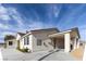 Stunning single-story home featuring a light-colored stucco exterior, covered parking, and well-manicured landscaping at 1409 Denver St, Boulder City, NV 89005