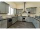 A modern kitchen features gray cabinetry, stainless appliances, and a large window at 1409 Denver St, Boulder City, NV 89005