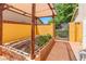 Backyard garden with garden beds, mature trees, a covered patio, and an outdoor fence at 1440 Rawhide Rd, Boulder City, NV 89005