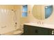 Bright bathroom with a shower/tub combo, updated vanity, and a large, round mirror at 1440 Rawhide Rd, Boulder City, NV 89005