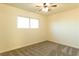 This carpeted bedroom includes a ceiling fan and a bright window at 1440 Rawhide Rd, Boulder City, NV 89005