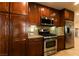 Gourmet kitchen with stainless steel appliances, granite counters, and rich wood cabinetry at 1440 Rawhide Rd, Boulder City, NV 89005
