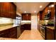 Well-lit kitchen featuring granite countertops, stainless steel appliances, and ample dark wood cabinetry at 1440 Rawhide Rd, Boulder City, NV 89005