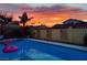 Relaxing backyard pool view at sunset with a pink flamingo float and poolside lounge area near a stucco fence at 1440 Rawhide Rd, Boulder City, NV 89005
