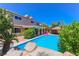 Backyard oasis featuring a sparkling pool, lush greenery, and a charming poolside tiki hut for ultimate relaxation at 1440 Rawhide Rd, Boulder City, NV 89005