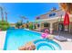 Stunning backyard pool with a built-in jacuzzi, waterfall features, swaying palm trees, and an inflatable flamingo at 1440 Rawhide Rd, Boulder City, NV 89005