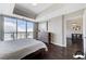 Stylish main bedroom with expansive windows offering city views, a dresser, and dark hardwood floors at 150 Las Vegas Blvd # 1118, Las Vegas, NV 89101