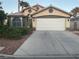 Charming single-story home featuring a well-maintained yard, a two-car garage, and arched window at 1800 Quail Point Ct, Las Vegas, NV 89117