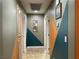 Hallway featuring textured walls, decorative art, neutral tile floors, and two doors at 1800 Quail Point Ct, Las Vegas, NV 89117