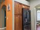 Kitchen area with wooden cabinets, stainless steel refrigerator, and nearby hallway at 1800 Quail Point Ct, Las Vegas, NV 89117