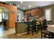 Open kitchen featuring granite countertops, wood cabinets, island seating, and tile flooring at 1800 Quail Point Ct, Las Vegas, NV 89117