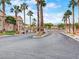 Welcoming community entrance with gated access and lush landscaping featuring mature palm trees under a bright sky at 2110 Los Feliz St # 1066, Las Vegas, NV 89156
