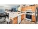 Open-concept kitchen featuring modern appliances, wooden cabinets, and a breakfast bar overlooking the living area at 2110 Los Feliz St # 1066, Las Vegas, NV 89156
