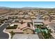 This aerial view showcases a neighborhood with desert landscape and mountains in the distance at 2400 Trissino Ct, Henderson, NV 89044