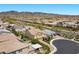 Aerial view of residential houses with mountain views and desert landscape and nearby streets at 2400 Trissino Ct, Henderson, NV 89044