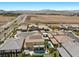 This aerial view displays the home, backyard pool with community, and surrounding desert landscape at 2400 Trissino Ct, Henderson, NV 89044