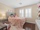 Bedroom with plantation shutters, and a fluffy pink bed creating a peaceful and inviting space at 2400 Trissino Ct, Henderson, NV 89044