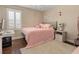 Bedroom featuring a fluffy pink bed, plantation shutters, wood floor and warm, neutral colored walls at 2400 Trissino Ct, Henderson, NV 89044