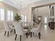 Formal dining area features a chandelier, a glass-top table with seating, and large windows at 2400 Trissino Ct, Henderson, NV 89044